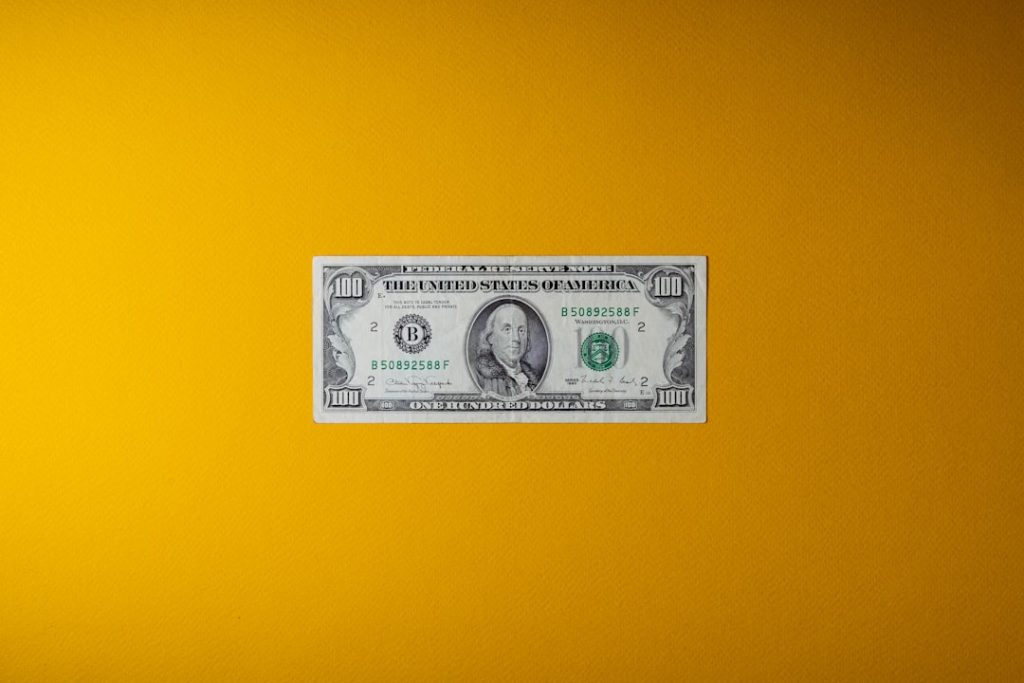 a one dollar bill sitting on top of a yellow wall