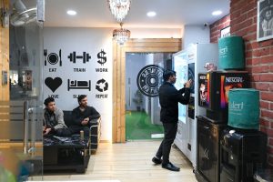 A gym interior with patrons and vending machines.