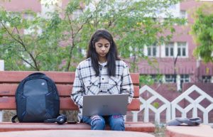 a woman sitting on a bench with a laptop