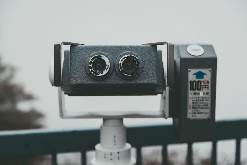 a pair of cameras sitting on top of a metal pole