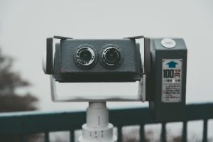 a pair of cameras sitting on top of a metal pole
