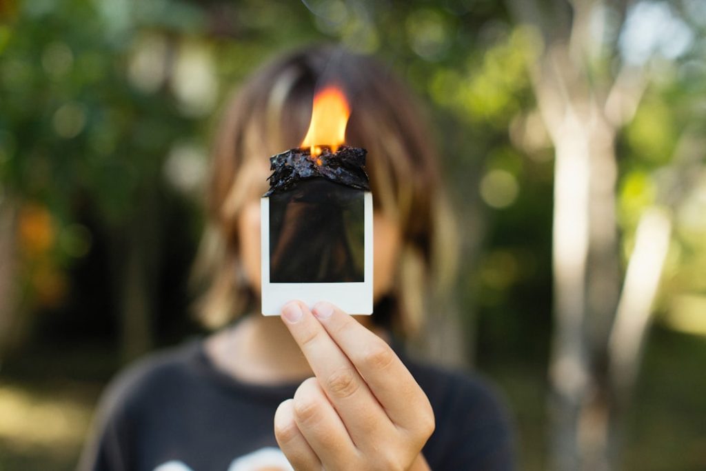 a woman holding up a cell phone with a flame on it