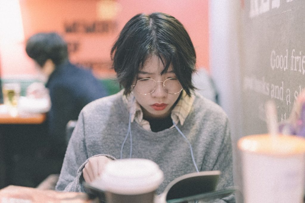 a person sitting at a table using a cell phone