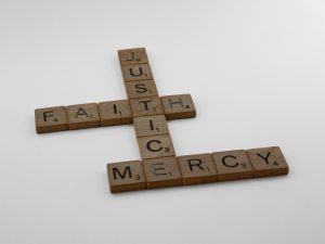 a cross made of scrabble tiles on a white surface